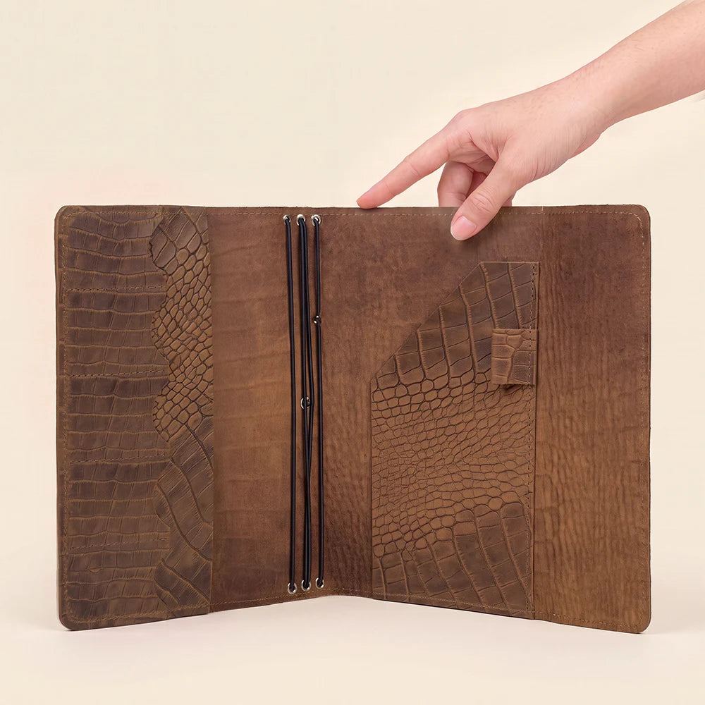 Leather notebook cover with practical interior pockets and three refillable elastic bands.