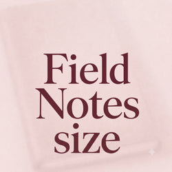 A close-up of a pale blush pink notebook cover with the words 'Field Notes size' printed in a dark burgundy serif font.