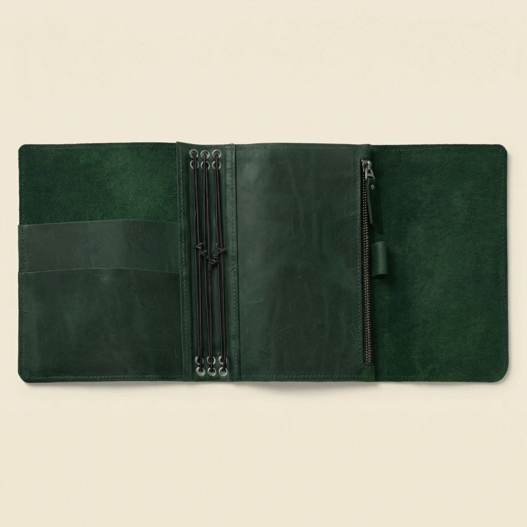 Green leather journal with zippers on a beige background