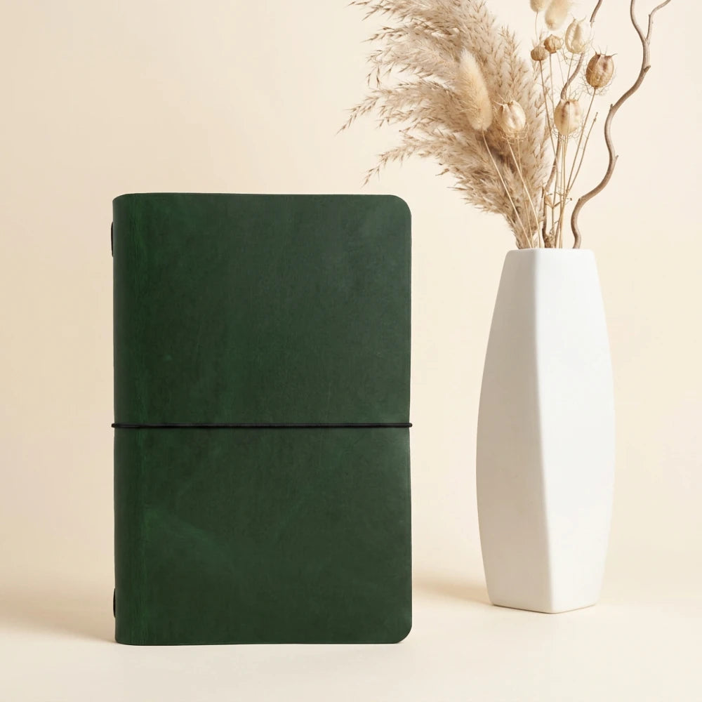 Open handmade leather notebook cover highlighting the simple insert and elastic loop.