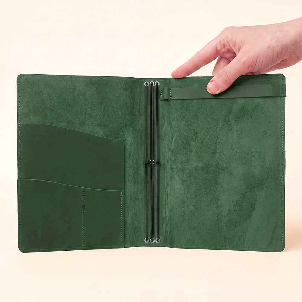 Handmade leather sketchbook holder with elastic straps, pockets, and refillable notebook design.