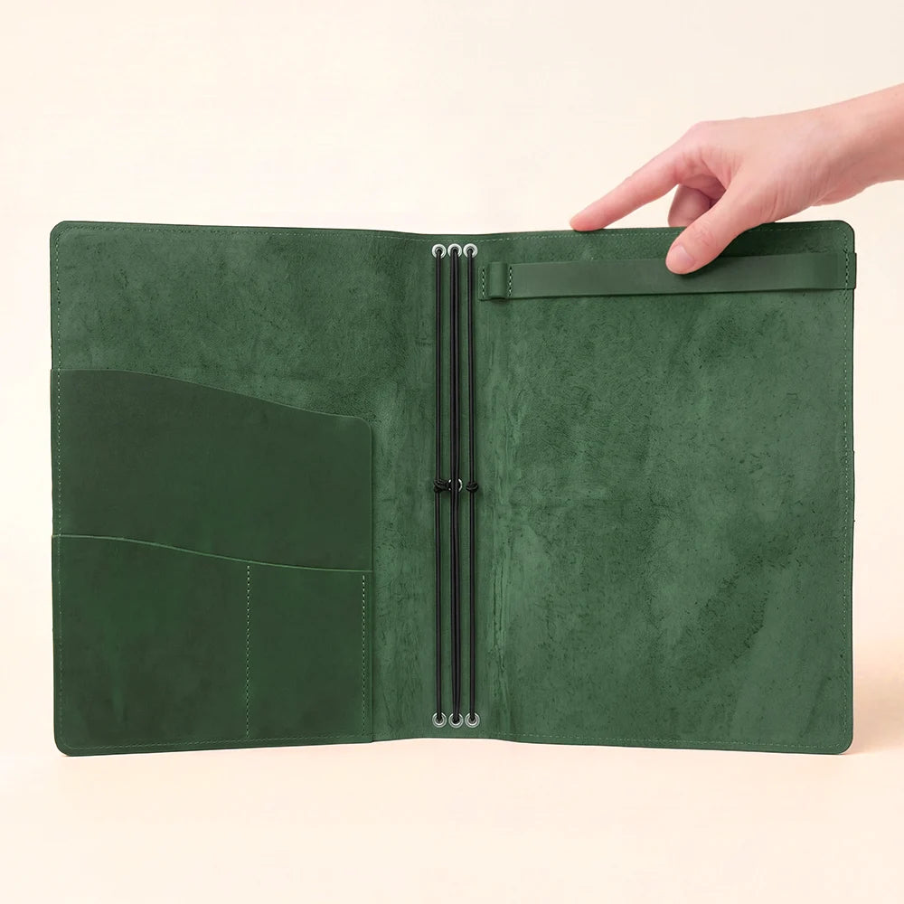 Open journal cover showing soft leather construction, elastic cords, and functional pockets.