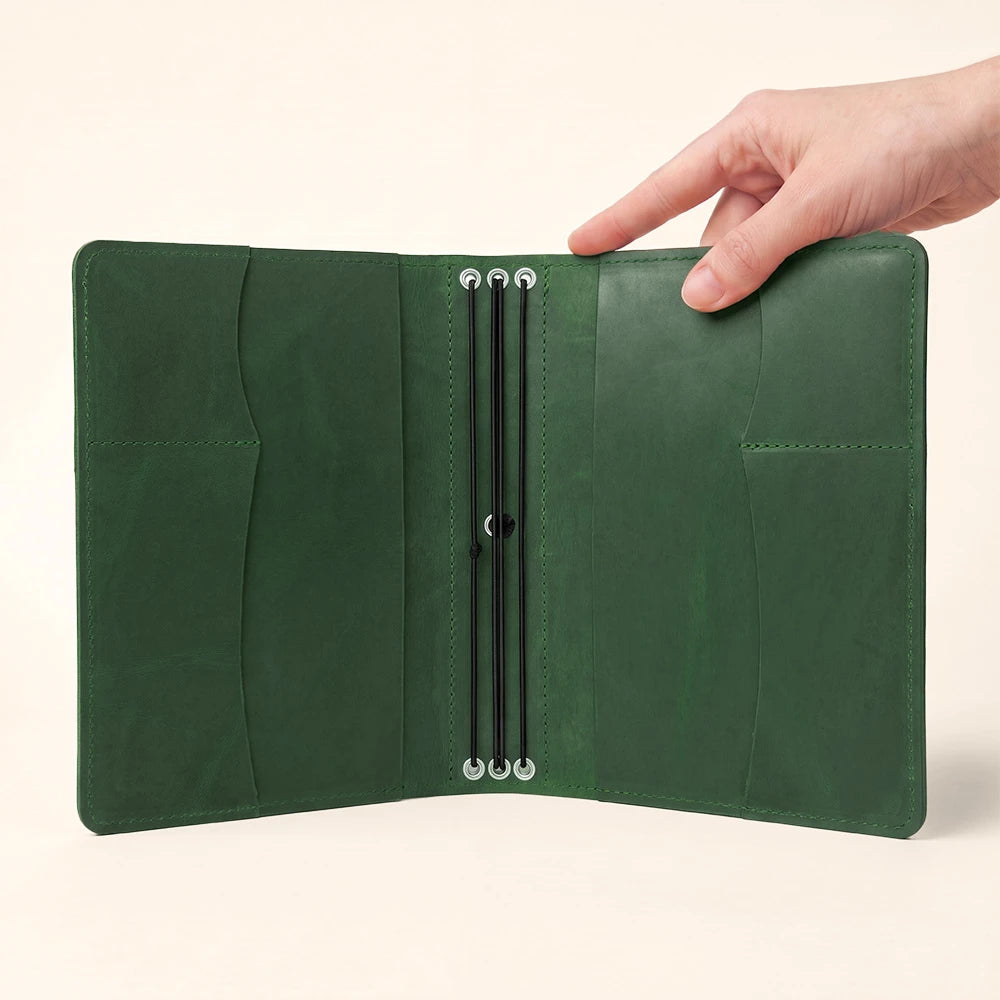 Refillable leather notebook cover with interior storage compartments and convenient pen holder.