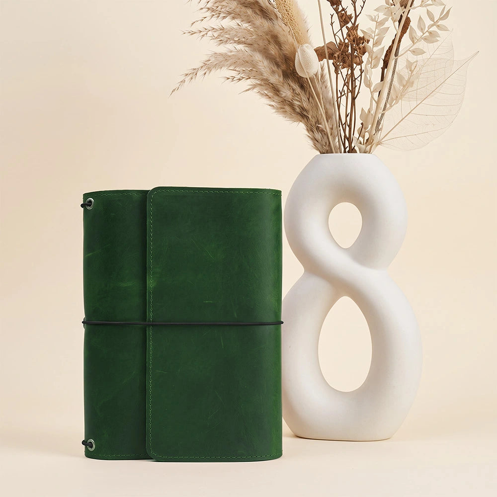 Genuine leather notebook holder with practical storage sleeves and integrated writing loop feature.