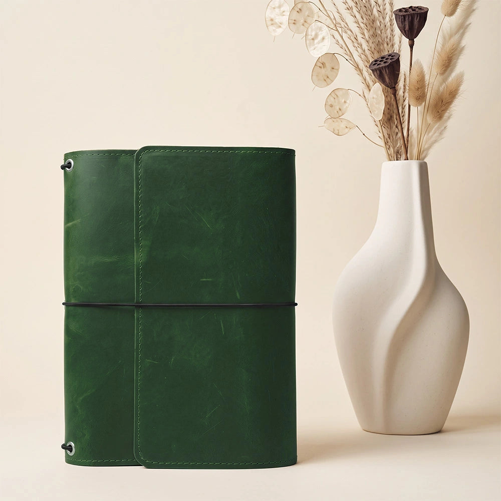 Natural leather notebook cover offering interior storage pockets and integrated pen holder.