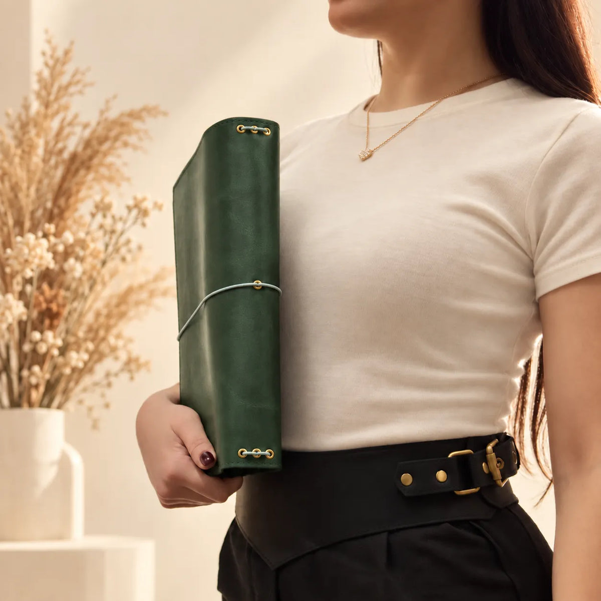 Young woman presenting a leather notebook cover with authentic grain and carefully finished edges.
