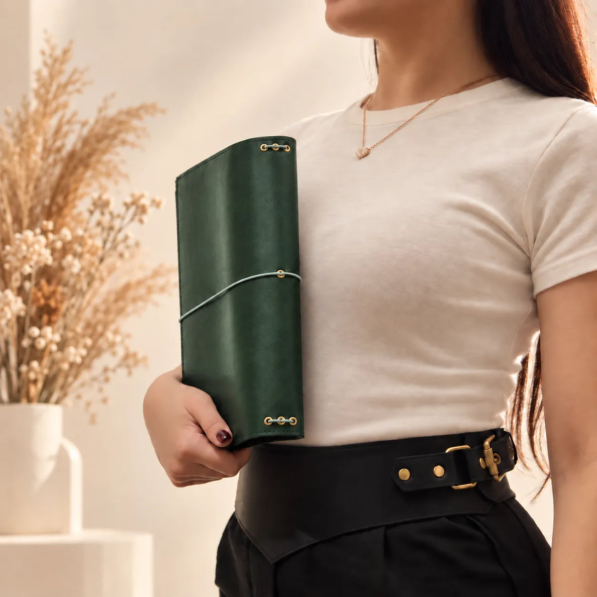 Young woman showcasing a handmade leather notebook cover with a durable natural leather construction.