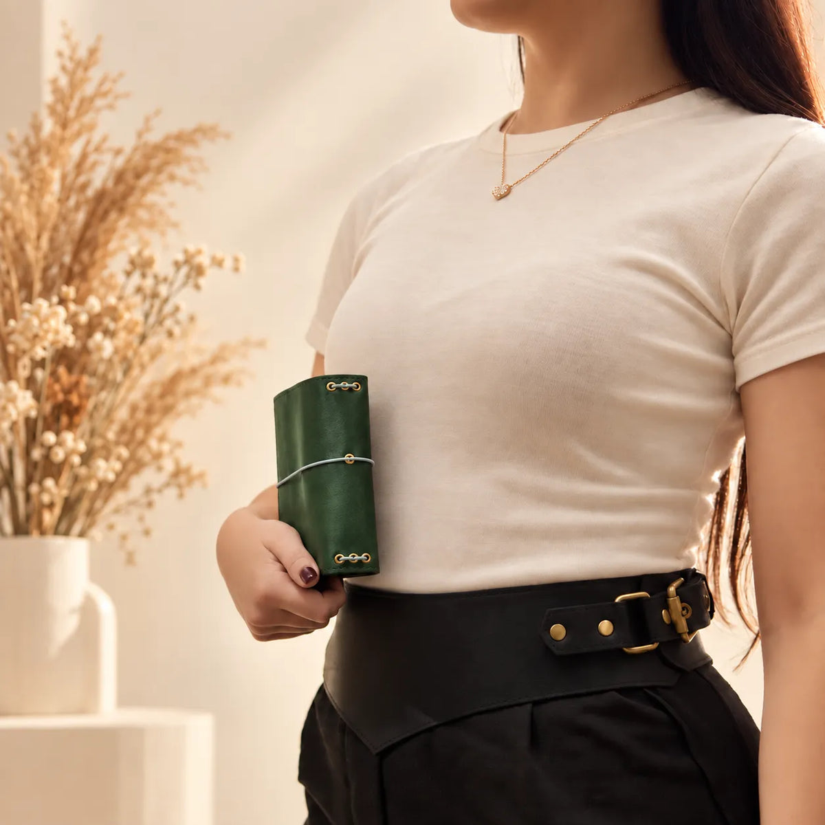 Woman displaying a natural leather journal cover with visible grain and handcrafted details.