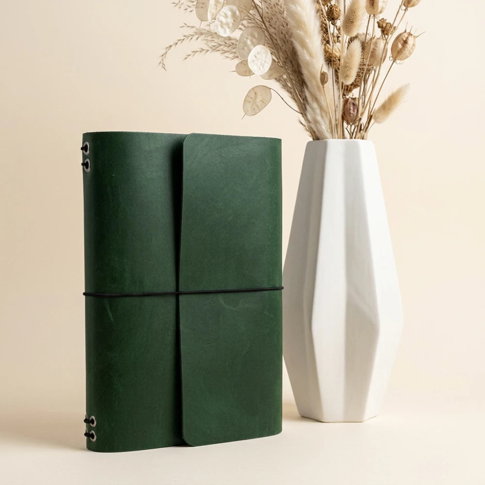 Leather planner cover with six elastic bands for organizing multiple notebook inserts.