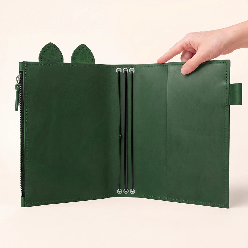 Refillable journal organizer designed with elastic retention and a roomy storage compartment.
