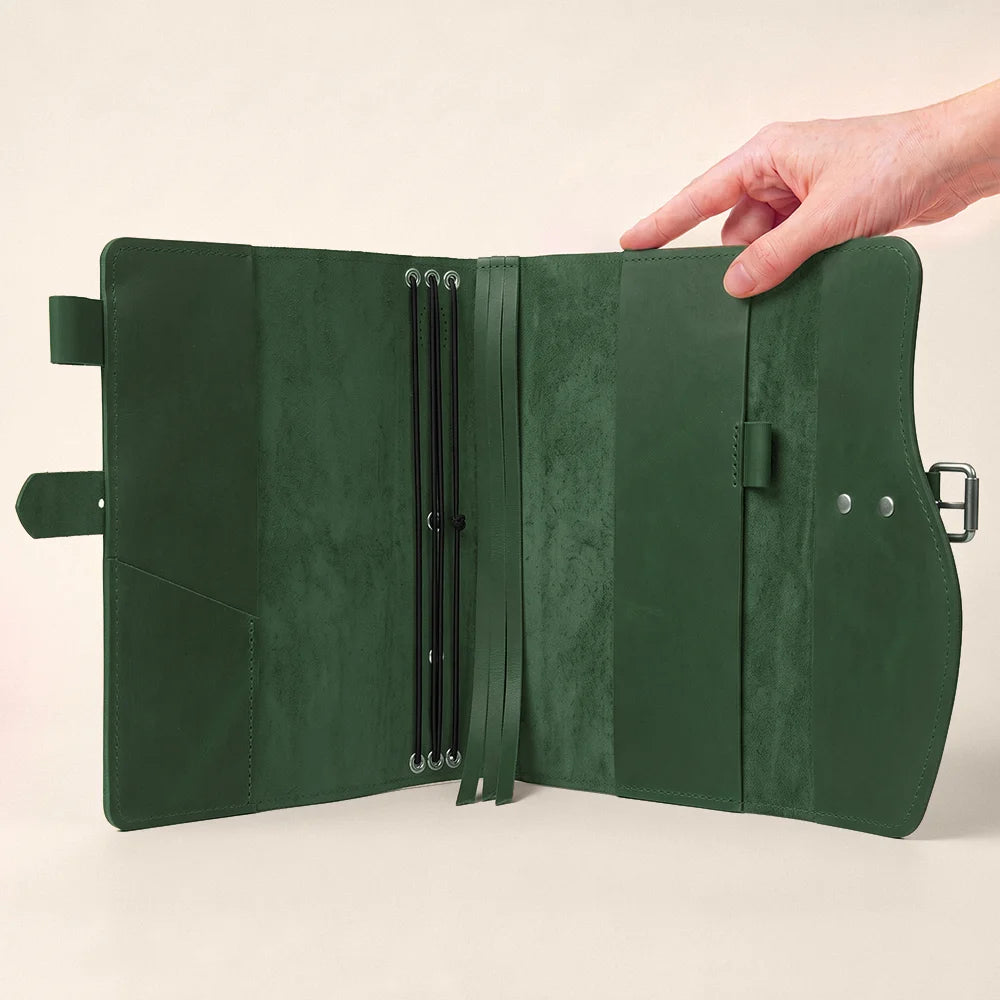 Leather notebook case with organized storage pockets, pen loop, integrated page marker, and outer grip.