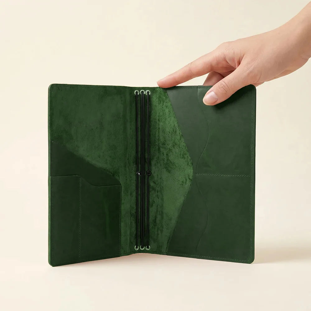 Green leather notebook organizer with multiple interior pockets and three elastic notebook bands.