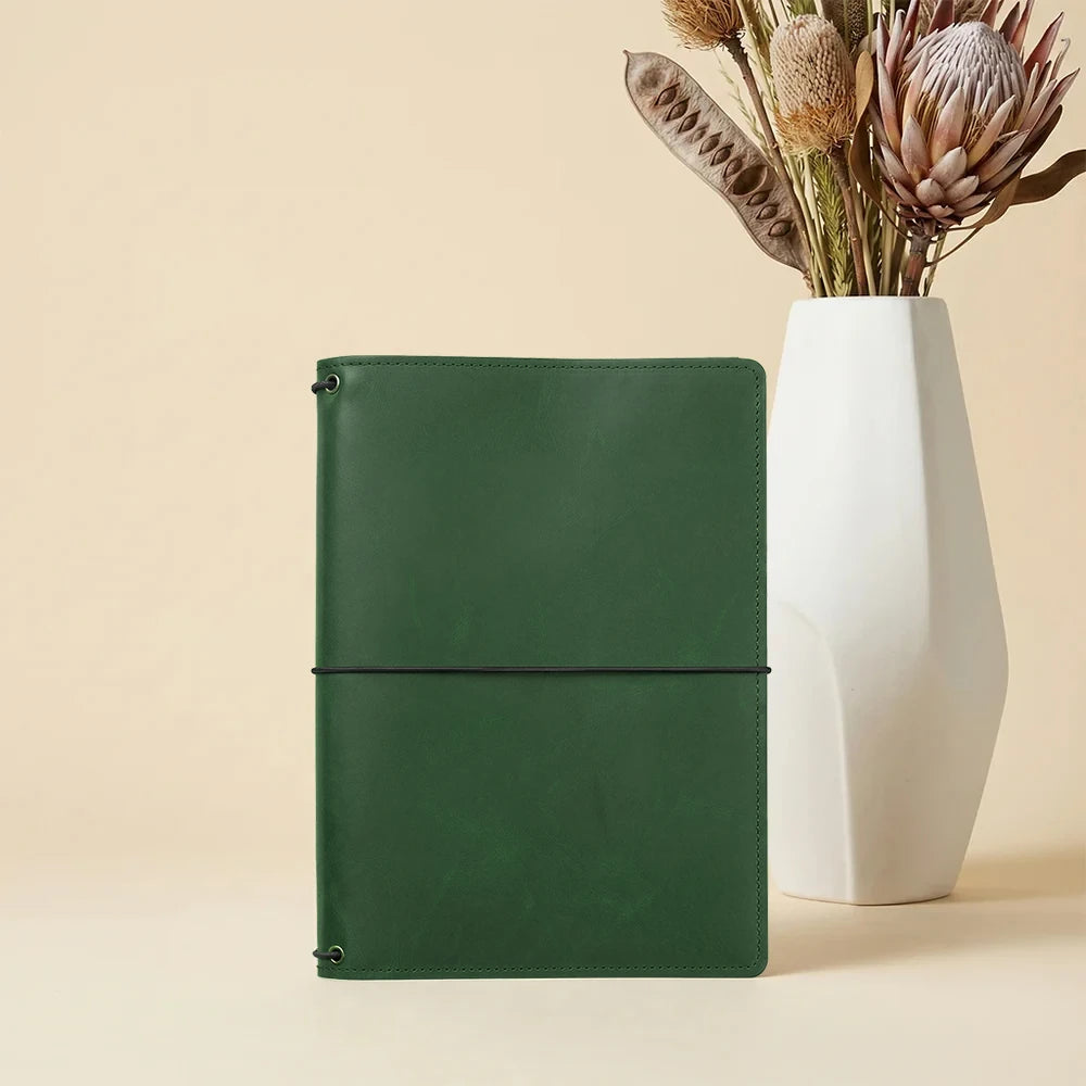 Handmade refillable leather notebook cover with interior pockets and three elastic notebook holders.