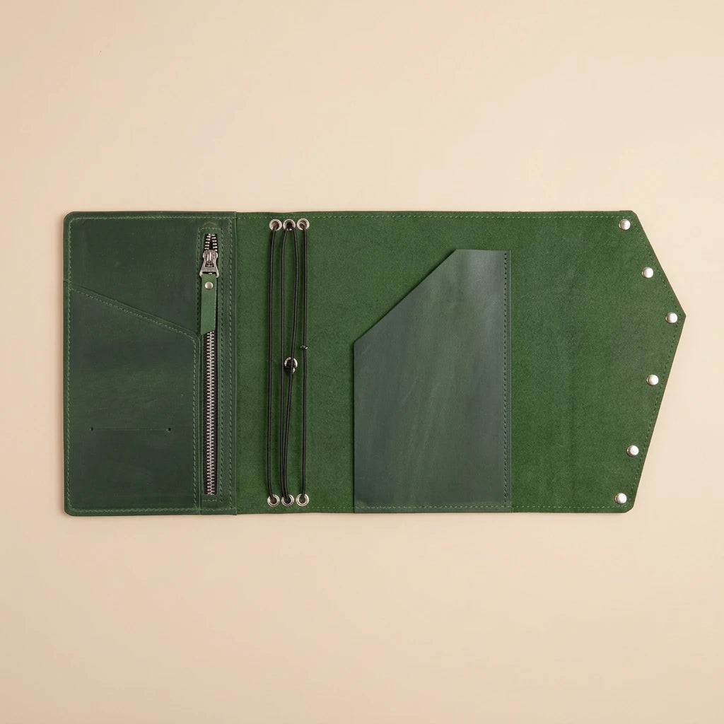 Green leather journal with zipper on a beige background