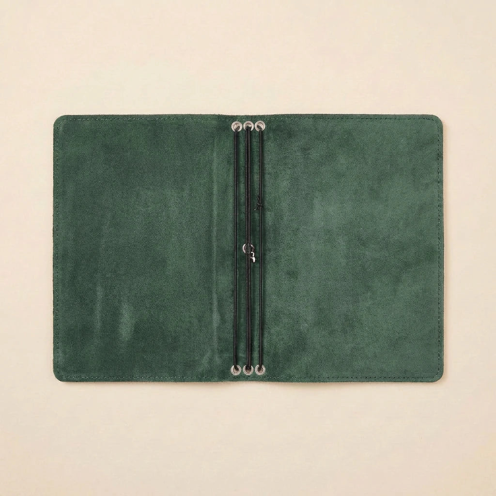 Green leather notebook with elastic bands on a beige background