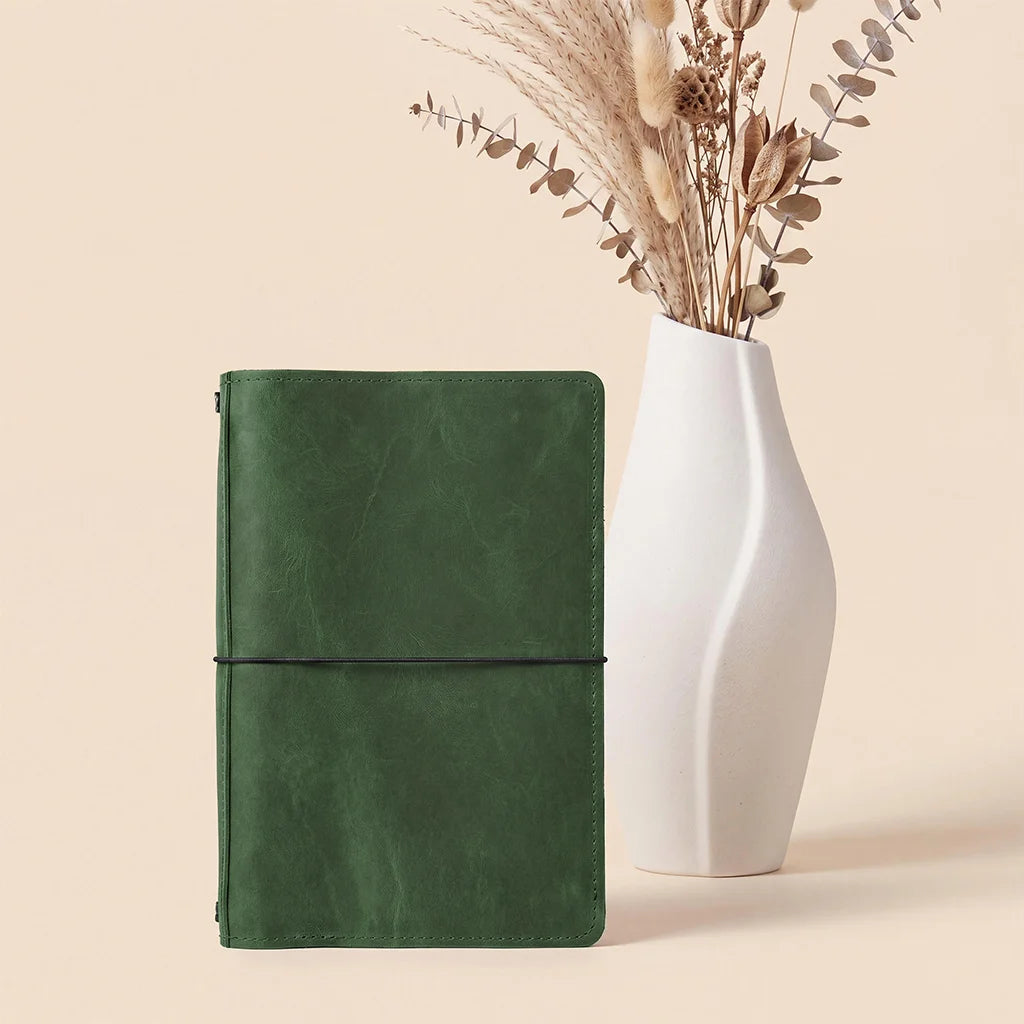 Handmade leather journal cover featuring card pockets and elastic bands for refillable notebooks.