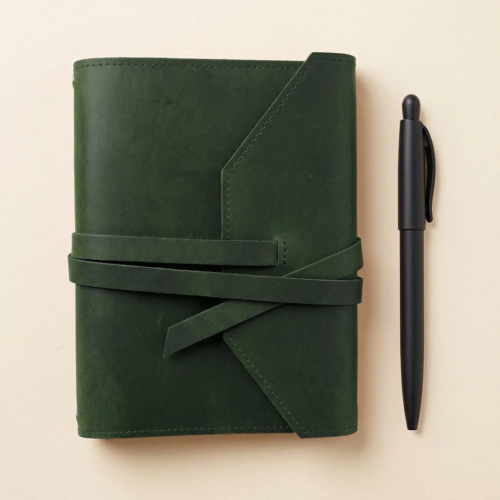 Handmade leather cover for journals with elastic fastening and pen holder detail.