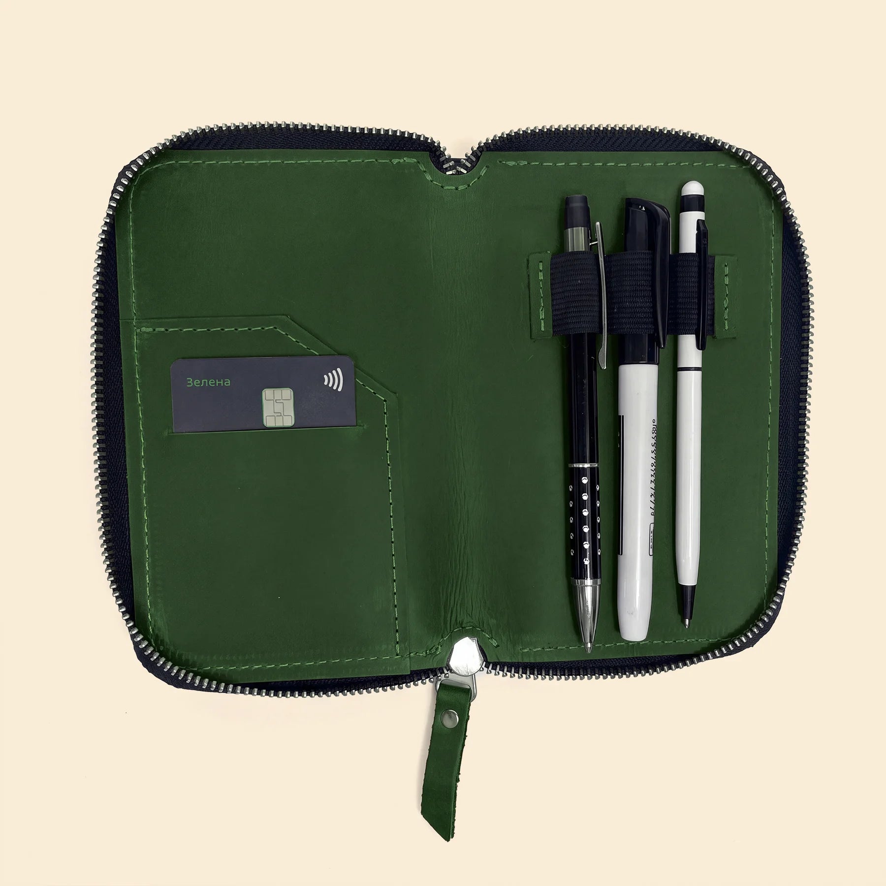 Compact leather organizer case with zipper for pens, pencils, and accessories.