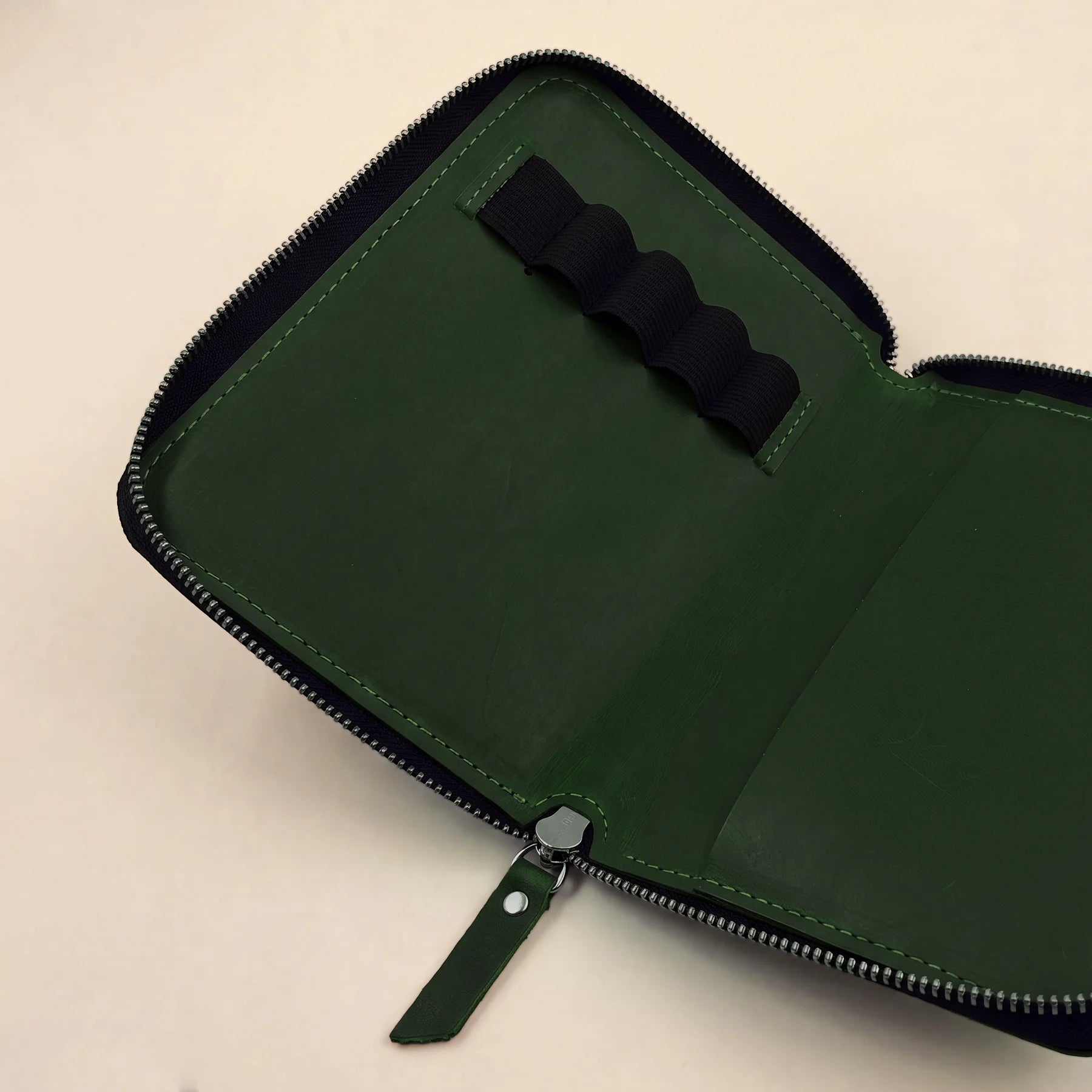 Full-grain leather pen carrier with zipper and compact profile for easy transport.