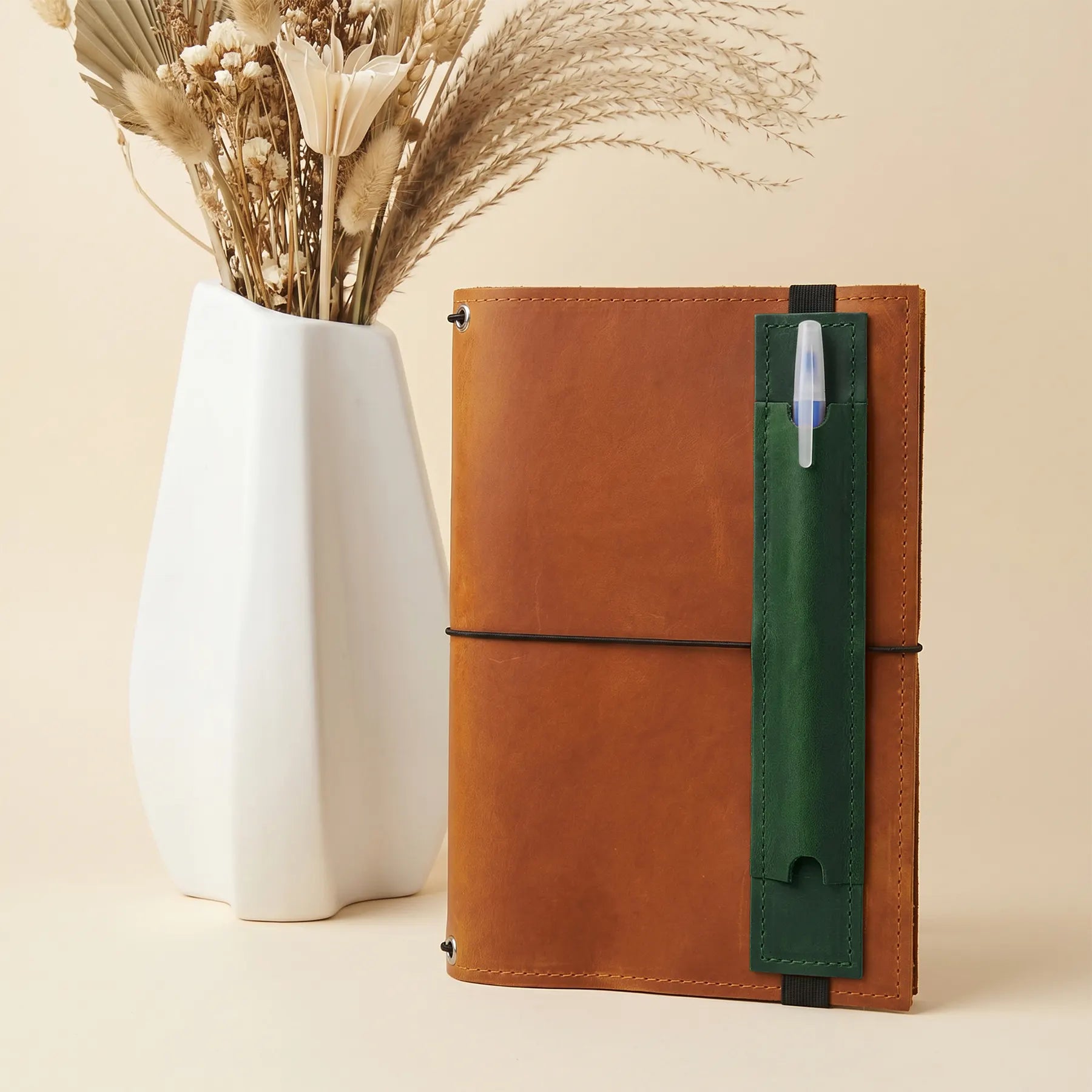 Genuine leather pen holder accessory for planners, journals, and refillable notebooks.