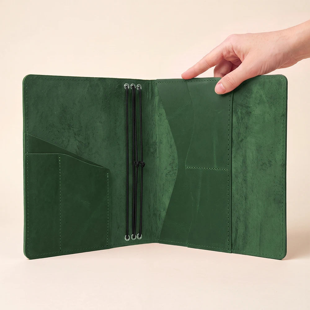 Leather travel journal case featuring handcrafted finish, interior compartments, and elastic notebook straps.