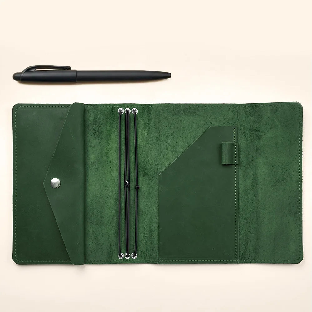 Refillable leather notebook cover with secure elastic bands and organized interior pocket layout.