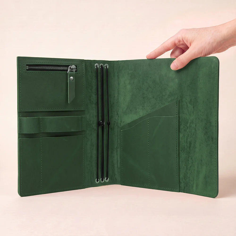 Genuine hide journal organizer featuring compact interior sections and dedicated writing instrument accommodation.
