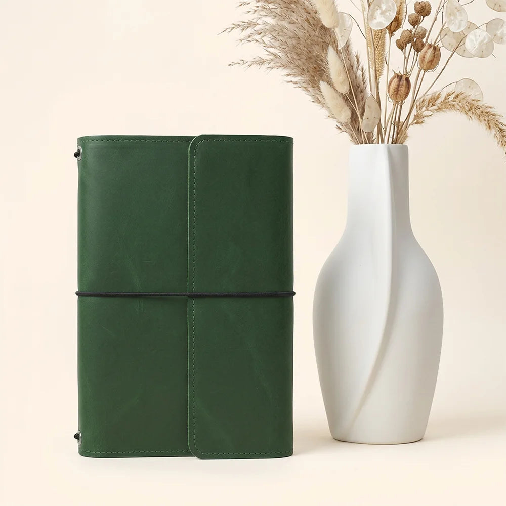 Leather journal cover with thoughtfully positioned compartments and an integrated loop for writing instruments.