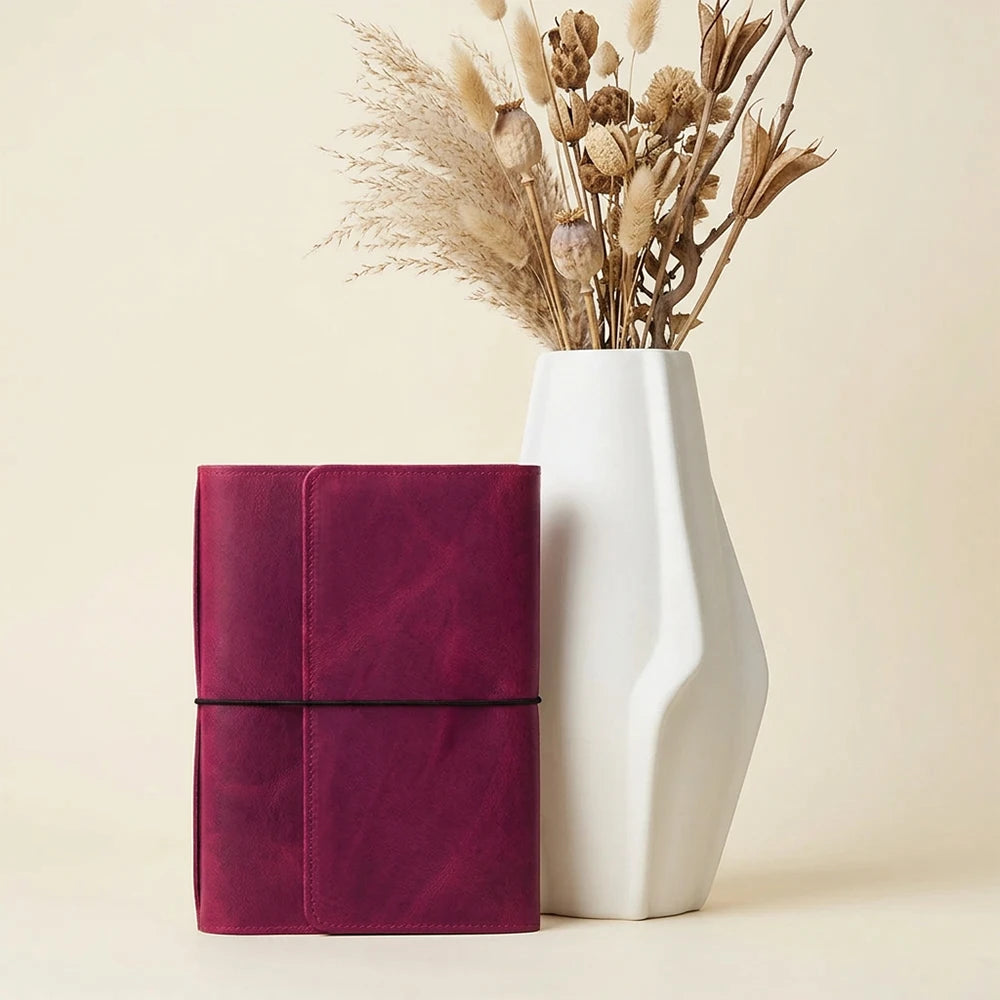 Handmade leather journal cover with six elastic bands and multiple storage compartments.