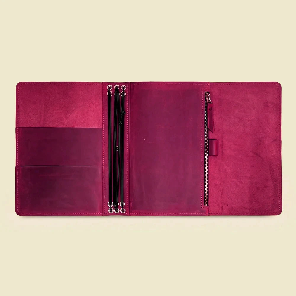 Natural leather journal cover with six elastic straps and several interior compartments.