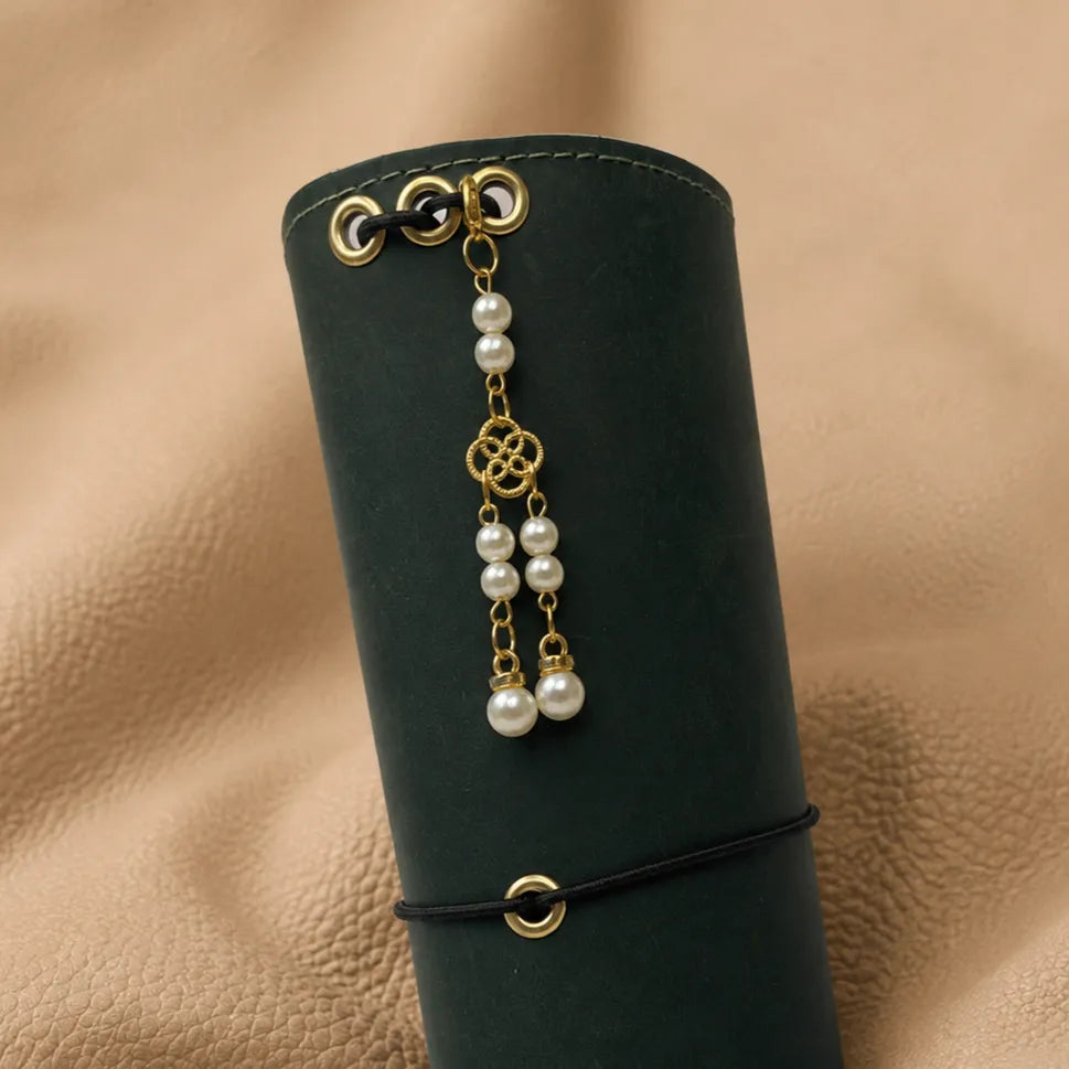Decorative journal charm attached to elastic notebook bands, stylish journal accessory.