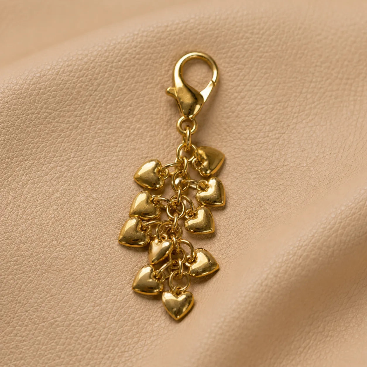 Decorative heart bead journal charm secured on notebook elastic bands, elegant handmade planner accessory.