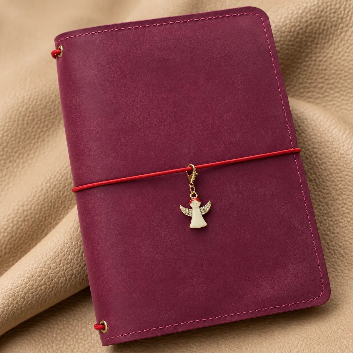 Small charm hanging from a notebook elastic as a delicate decorative accent.