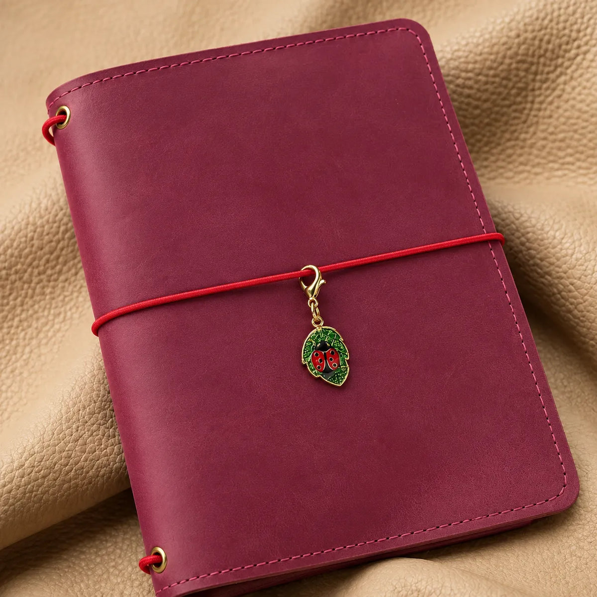 Small journal charm with dangling details attached to a stylish notebook cover.