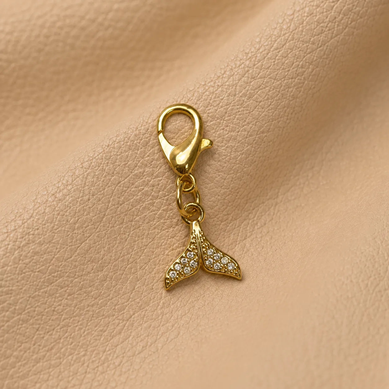 Decorative whale tail notebook charm secured on elastic bands, stylish journal embellishment accessory.