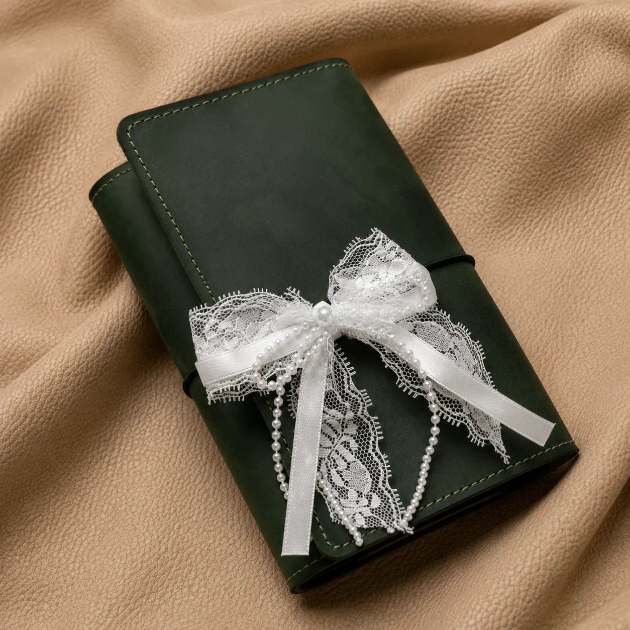 Decorative journal charm attached to elastic band of leather notebook cover