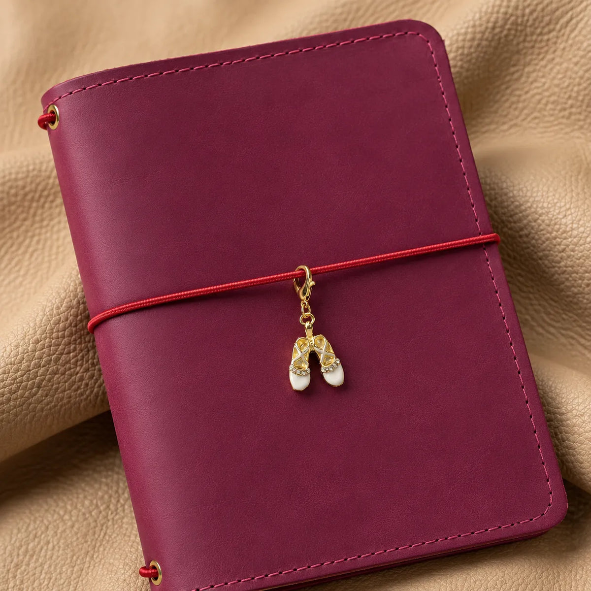 Elegant beaded charm hanging from a leather journal cover as a stylish accessory.