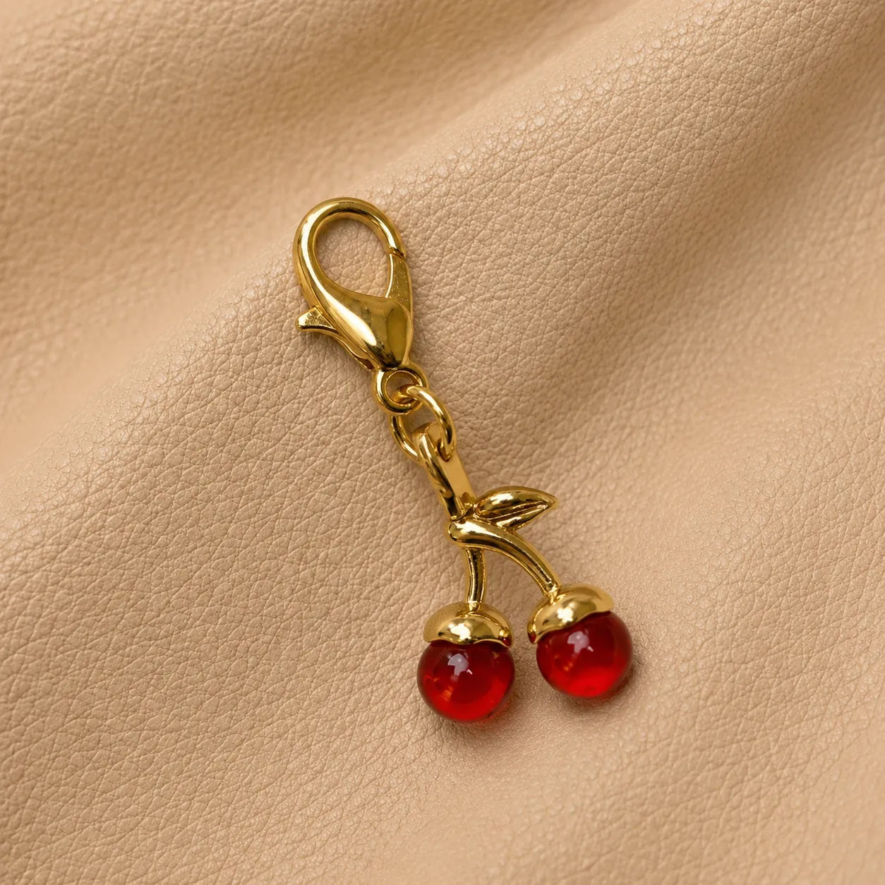 Cherry journal charm attached to elastic bands, decorative notebook accessory with metal clasp and beads.