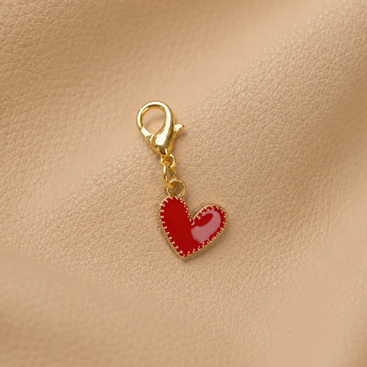 Close-up of a heart bead charm attached to a leather journal as a stylish accessory
