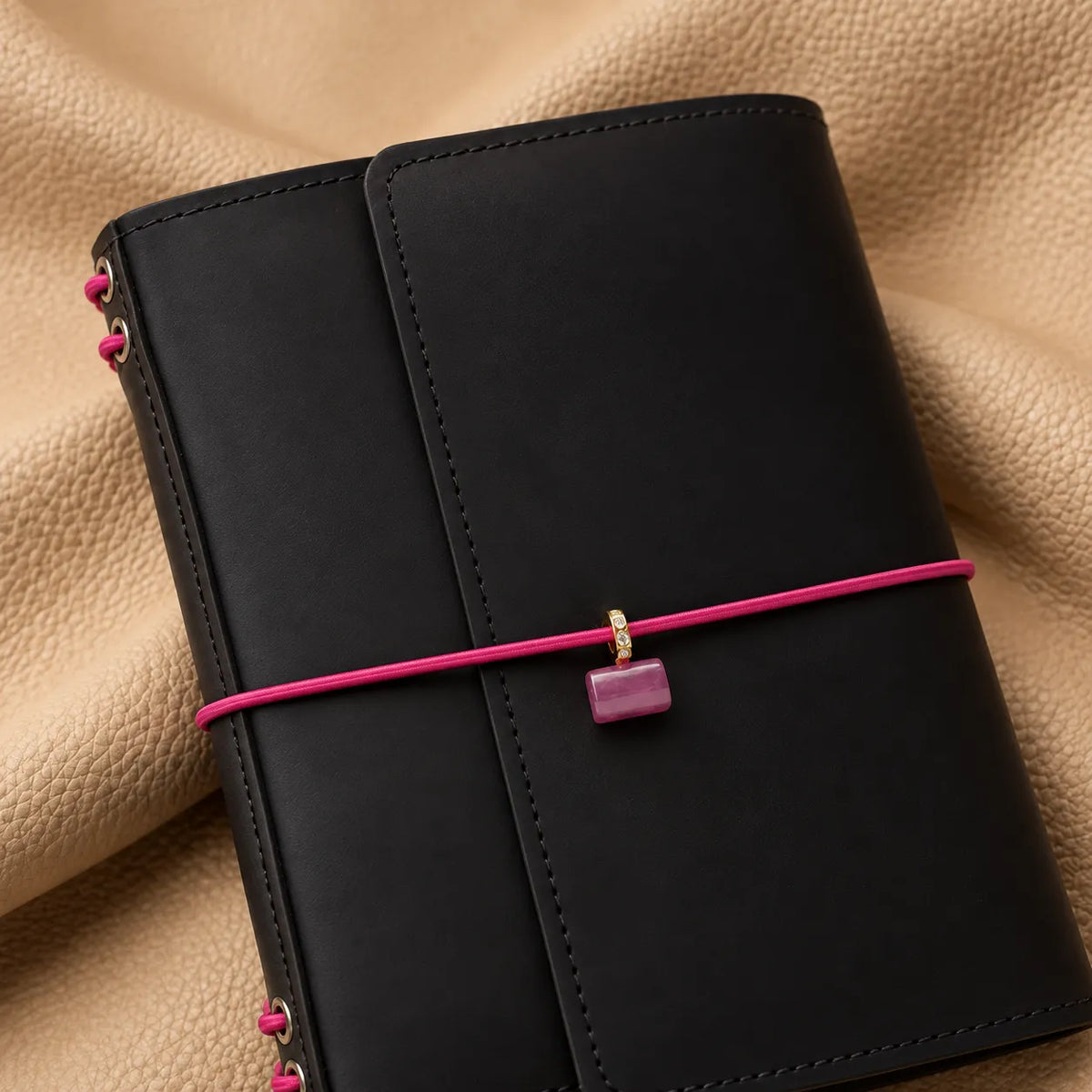 Delicate journal charm adding a graceful decorative element to a leather notebook cover.