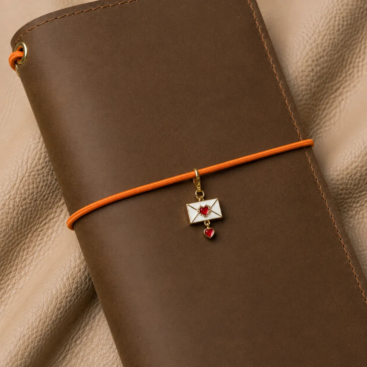 Decorative envelope charm for journal elastic bands, stylish notebook accessory with secure metal attachment.