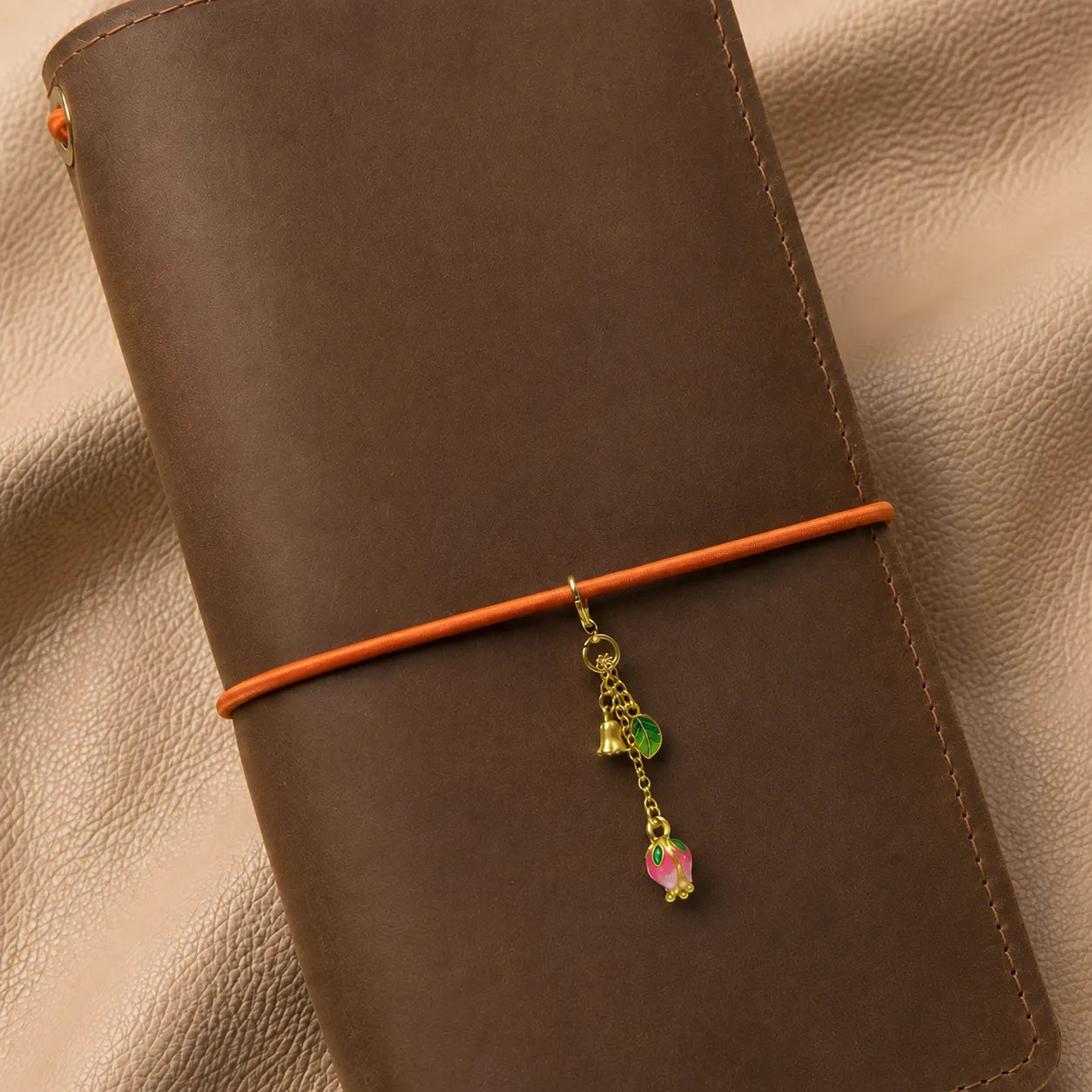 Flower-shaped journal charm attached to notebook elastic bands with elegant decorative bead.