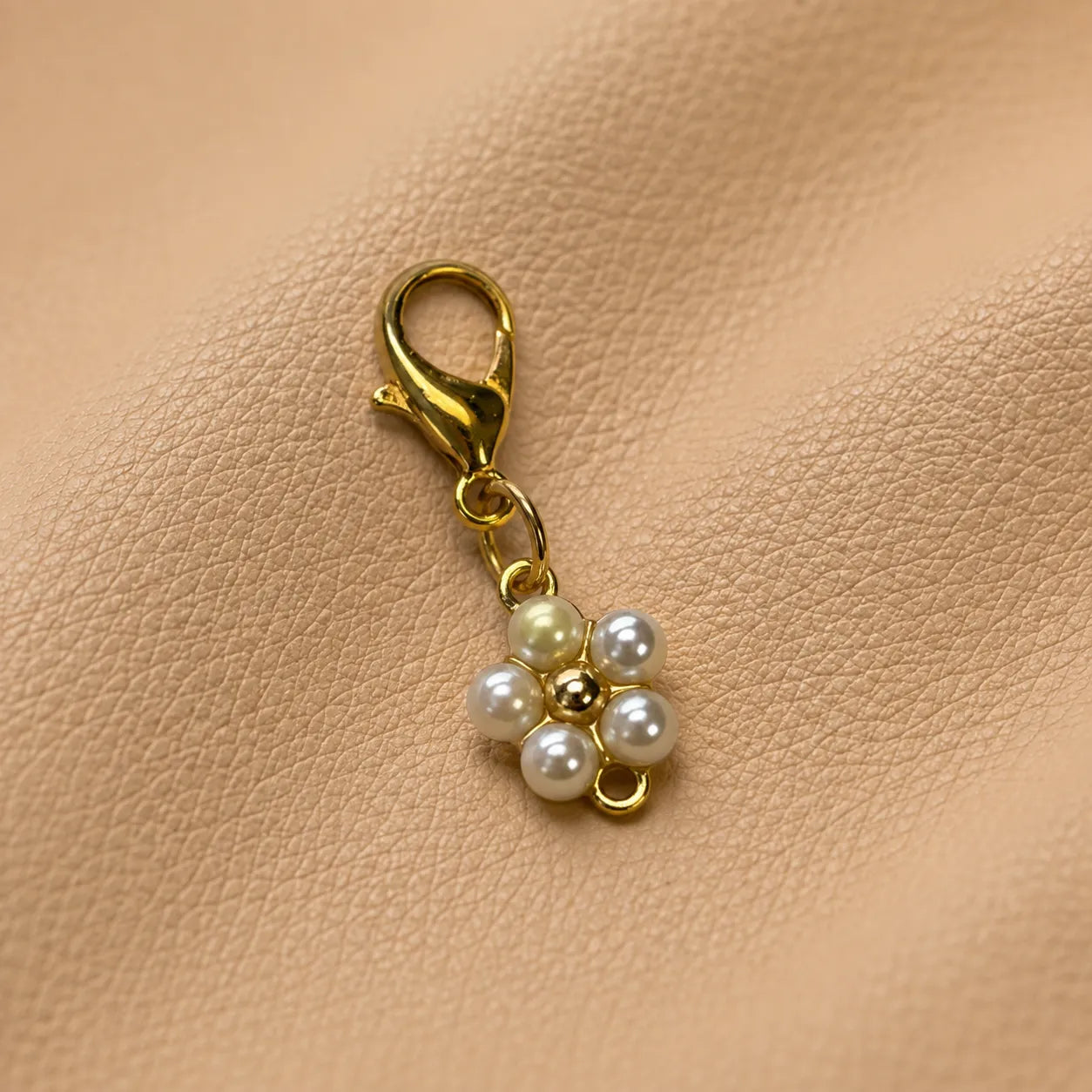 Close-up of floral notebook charm secured on elastic bands, stylish journal decoration accessory.