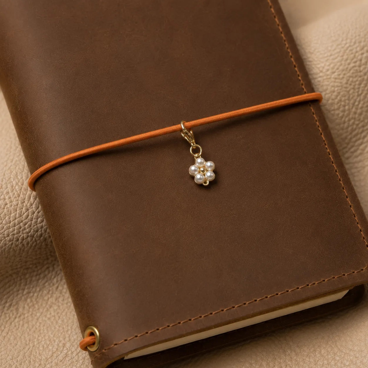 Flower-shaped journal charm attached to notebook elastic bands, elegant decorative accessory for planners.