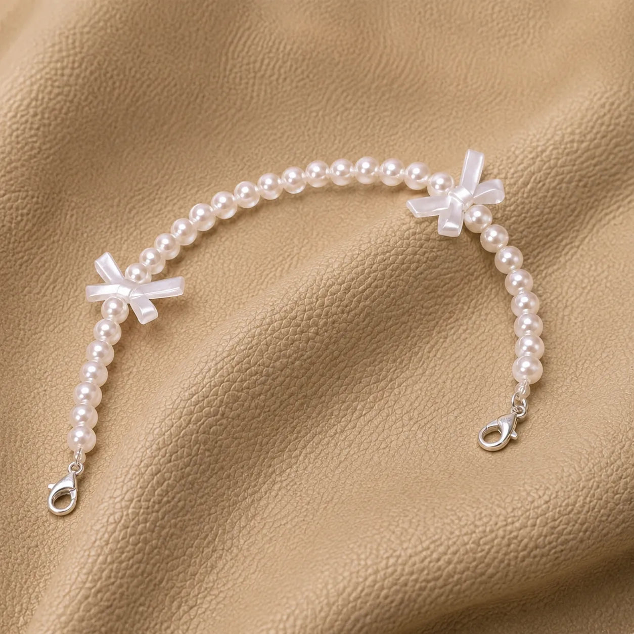 Beaded journal charm attached to a leather notebook elastic band.