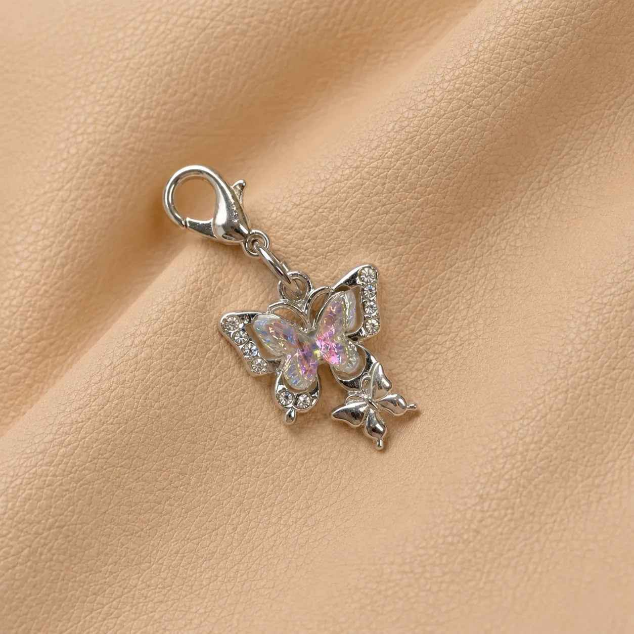 Close-up of a butterfly notebook charm featuring a butterfly-shaped bead and metal attachment.
