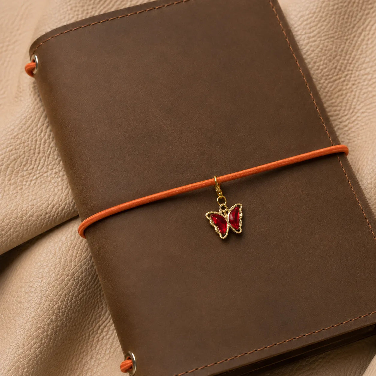 Butterfly journal charm attached to elastic bands, elegant decorative accessory for traveler's notebook.
