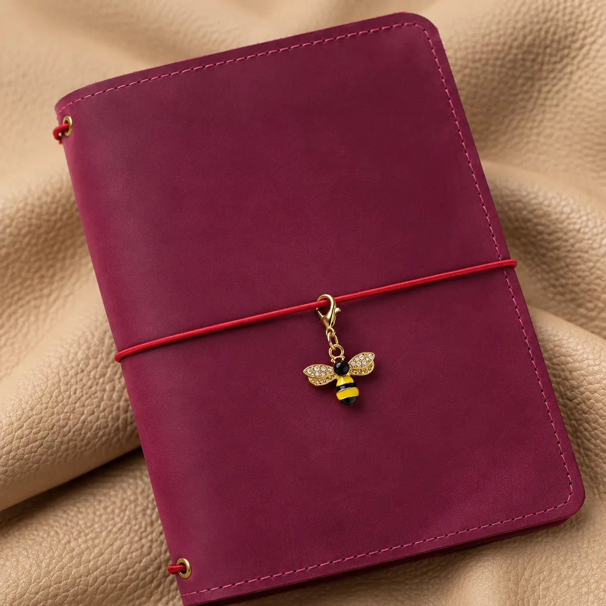 Elegant bead accessory attached to a journal elastic for a refined decorative look.