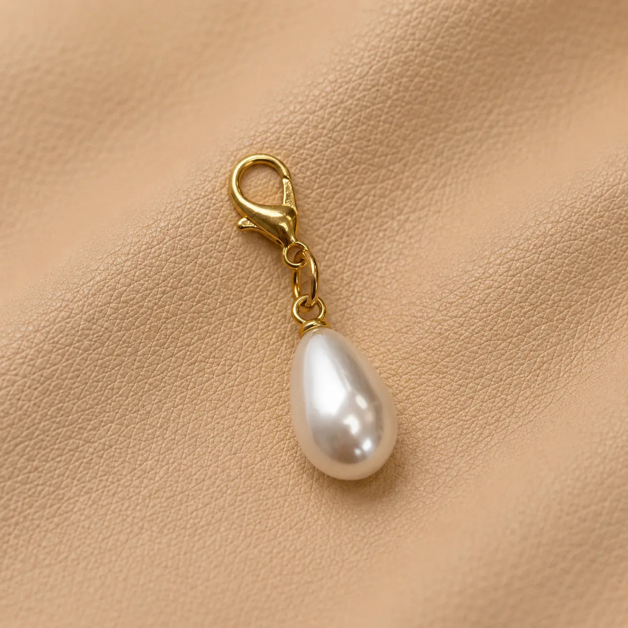 Close-up of decorative journal charm with metal clasp, stylish bead accessory for notebook elastics.
