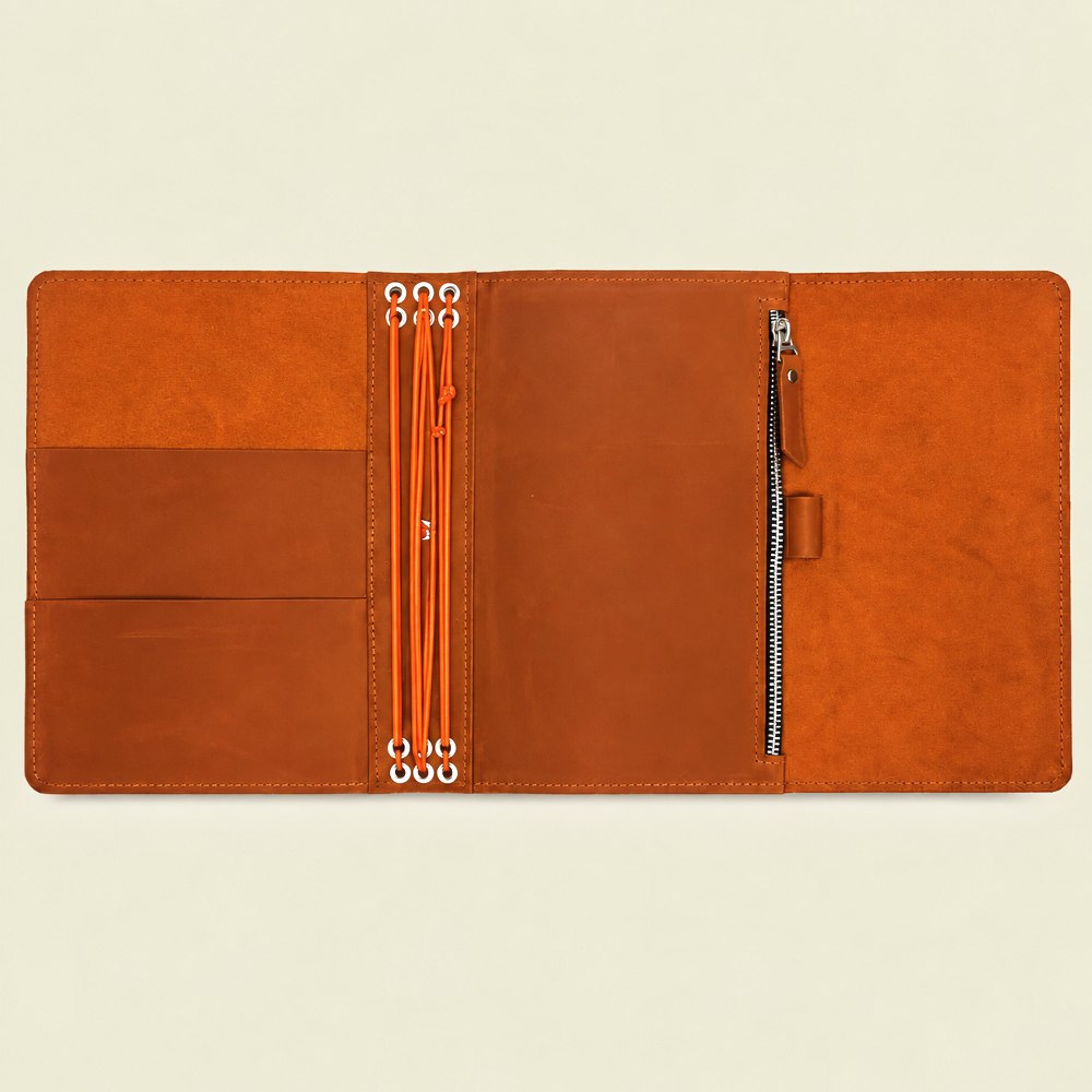 Orange genuine leather notebook cover with six elastic bands and convenient interior pockets.
